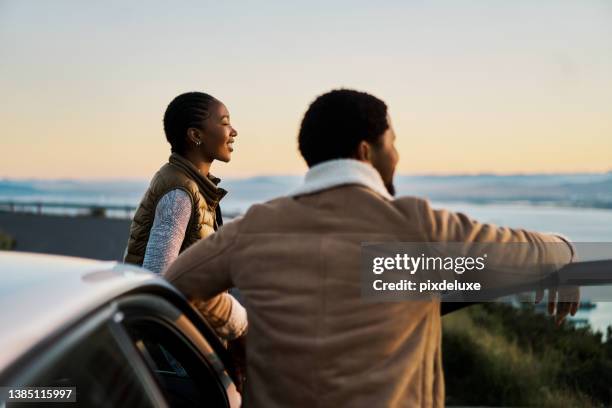 shot of a young couple admiring the view on a road trip - african ethnicity car stock pictures, royalty-free photos & images