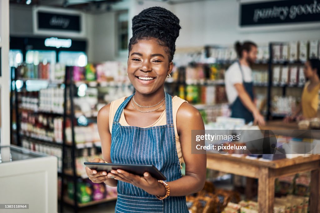Shot of a young woman using a digital tablet while working in an organic store