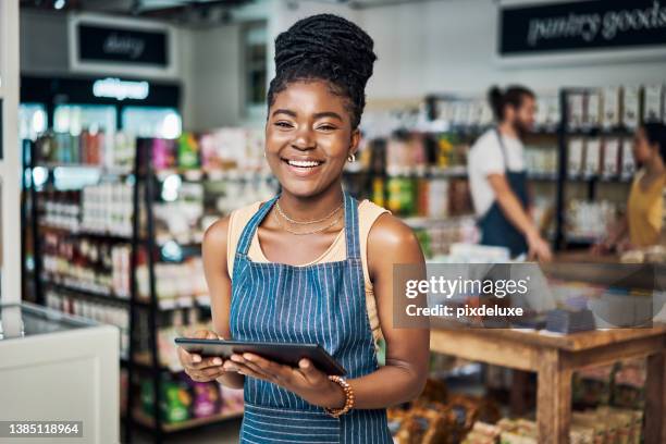 shot of a young woman using a digital tablet while working in an organic store - africa 個照片及圖片檔