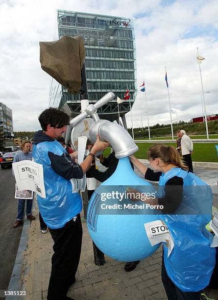 Demonstrators hold a large tap to protest against role that Dutch ING Bank plays in the privatization of water in Cochabamba, Bolivia September 16,...