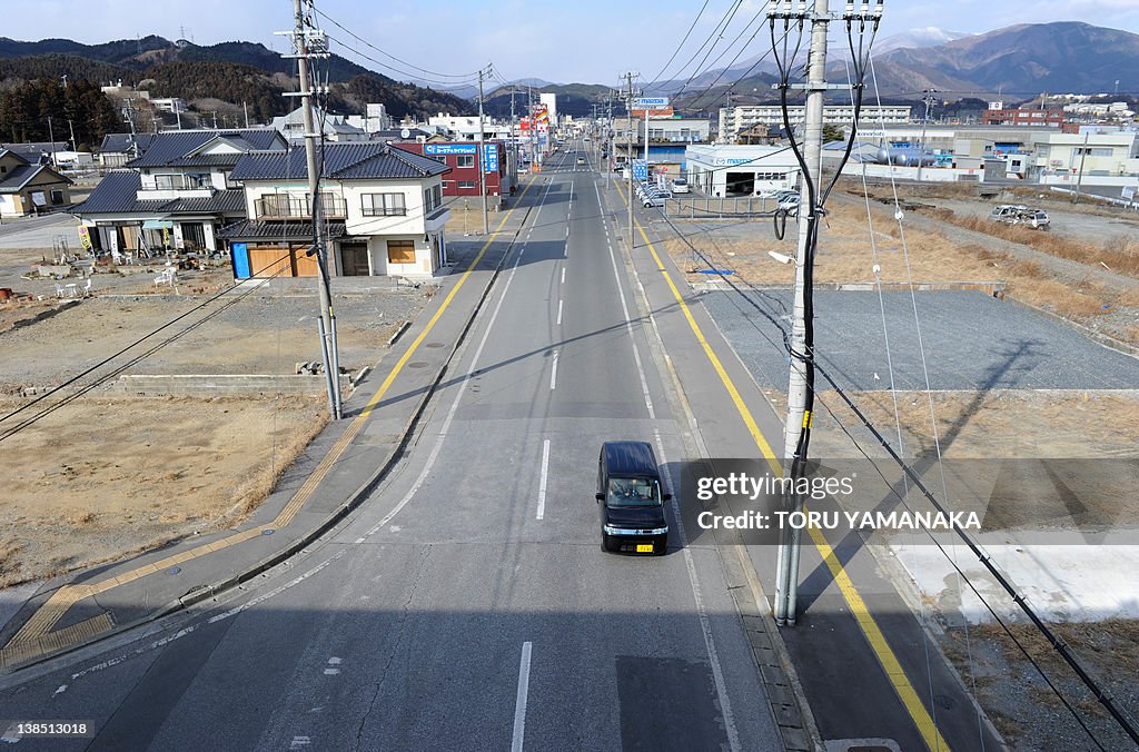 A car drives down an empty street in Ofu