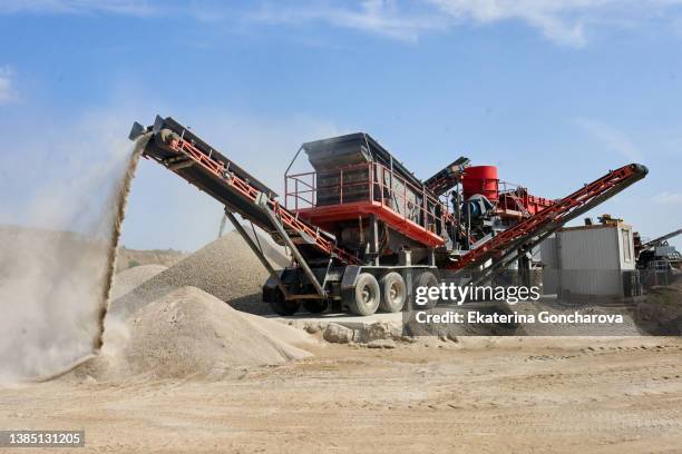 crushing machine in a sand quarry. summer, sunny weather - mina de superficie fotografías e imágenes de stock