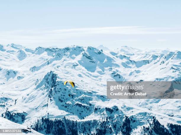 paragliding the beautiful french alps covered with snow and blue colors. - paragliding stock pictures, royalty-free photos & images