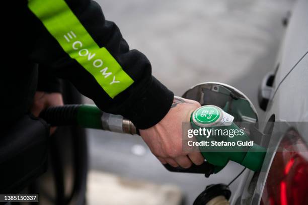 Hand of fuel man refueling a car with gasoline at a petrol station on March 14, 2022 in Turin, Italy. Oil and gas prices are hitting record highs...