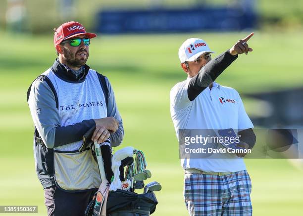 Anirban Lahiri of India prepares to play his second shot on the par 4, 18th hole with his caddie Tim Giuliano during completion of the weather...