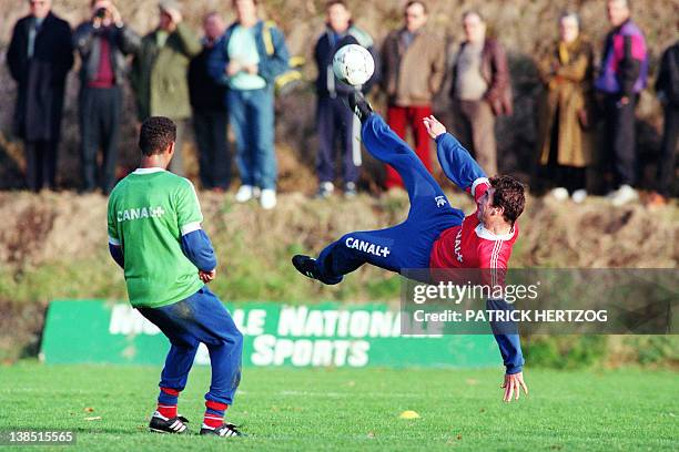 French striker Eric Cantona does a scissors kick in front of Franck Silvestre on November 18, 1991 in Clairefontaine during a training of the French...