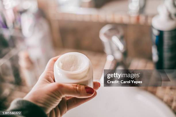 female hand with facial anti age  cream.bathroom gives space to copy - 潤膚乳液 個照片及圖片檔