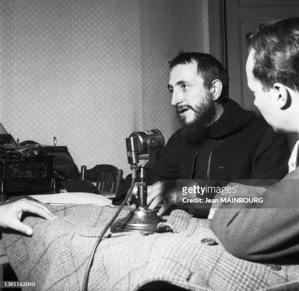 Abbé Pierre enregistrant son appel d'aide aux sans-abris pour l'édition d'un disque par Pathé-Marconi, à l'hôtel Bristol, en 1954, à Paris.