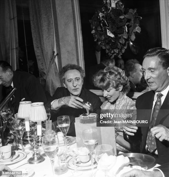Charles Trenet célébrant son Disque d'Or avec Jean Cocteau et Jacqueline Pagnol au restaurant 'Maxims', en octobre 1955, à Paris.
