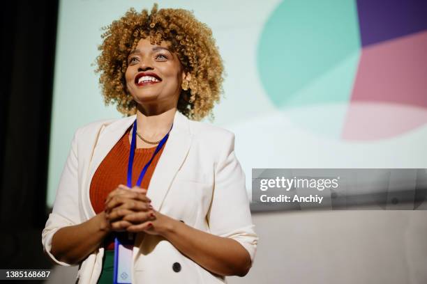 close up of a visionary female speaker smiling and looking at the audience - luidspreker stockfoto's en -beelden