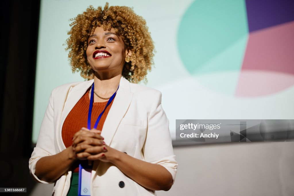 Close up of a visionary female speaker smiling and looking at the audience