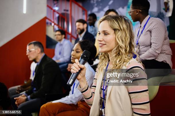 curious woman asks question during panel discussion - q and a panel stock pictures, royalty-free photos & images