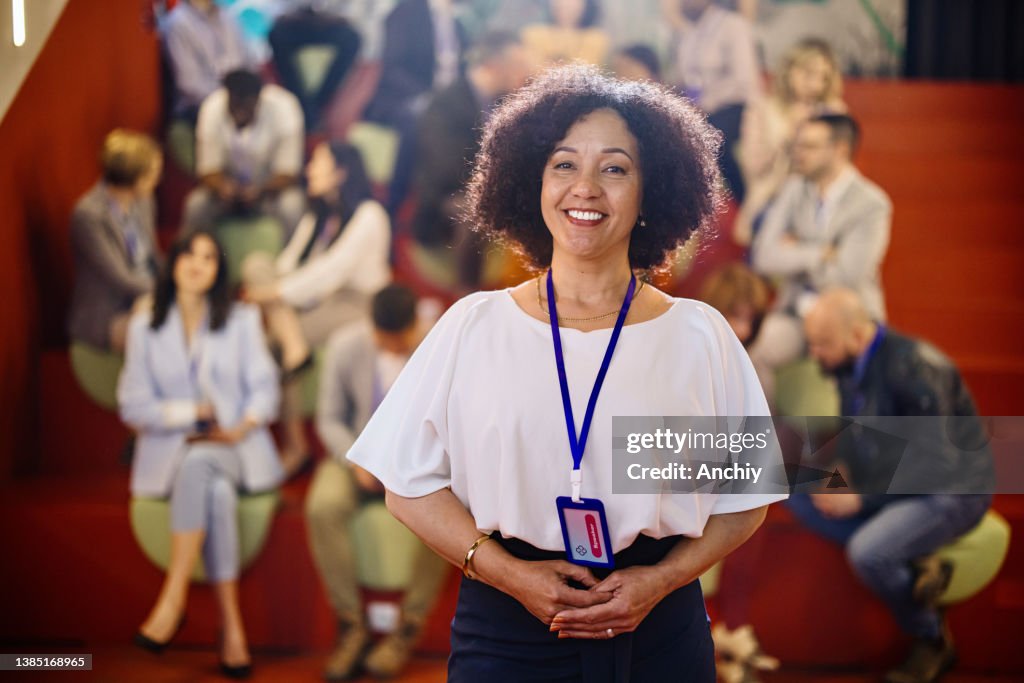 会議イベントで笑顔の話者、中年の成人女性の肖像画