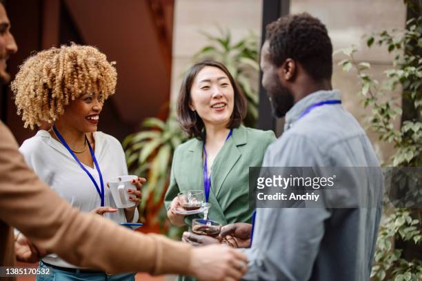 gli uomini d'affari multietnici parlano durante una pausa caffè - coffee meeting with friends foto e immagini stock