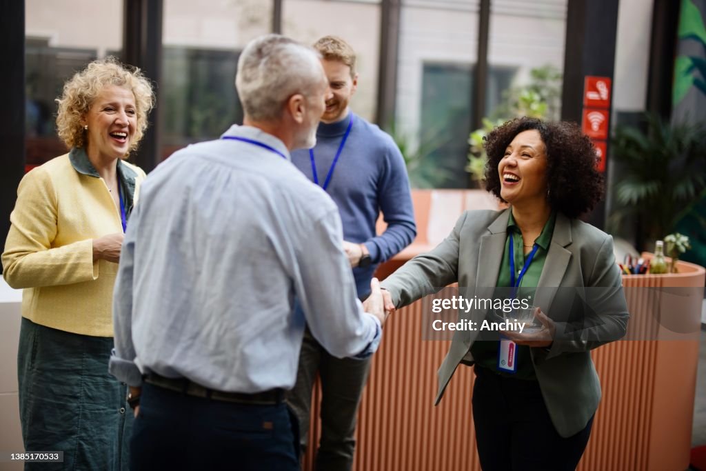 Business people greet each other during a coffee break at a conference