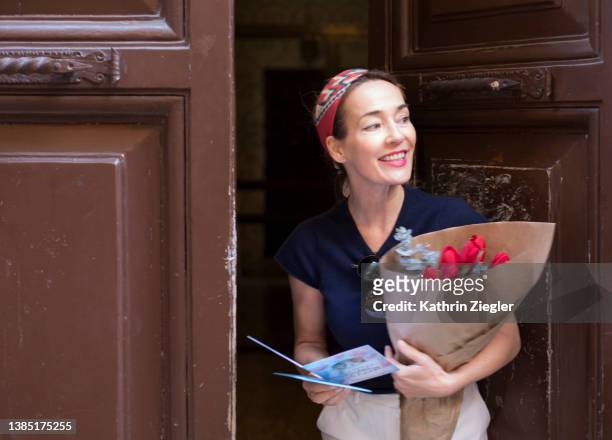 woman receiving a flower bouquet with greeting card - receiving card stock pictures, royalty-free photos & images