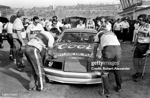 Members of NASCAR driver Bill Elliott's racing team prepare their racecar for the mandatory NASCAR inspection in the speedway garage prior to the...