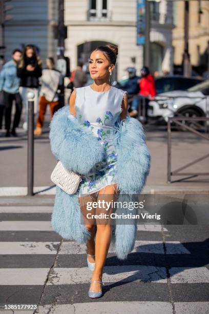 Camila Coelho seen wearing white dress with floral print, turquoise faux fur coat, white bag, silver shoes outside Miu Miu during Paris Fashion Week...