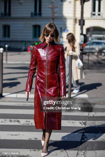 Anya Ziourova seen wearing bordeaux red colored zipper coat, sheer tights, white heels outside Miu Miu during Paris Fashion Week - Womenswear F/W...