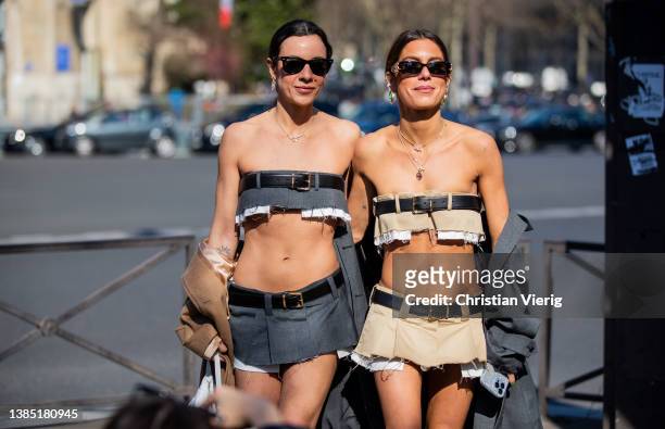 Guests seen wearing cropped top, mini skirt, beige coat, grey knee high socks outside Miu Miu during Paris Fashion Week - Womenswear F/W 2022-2023 on...