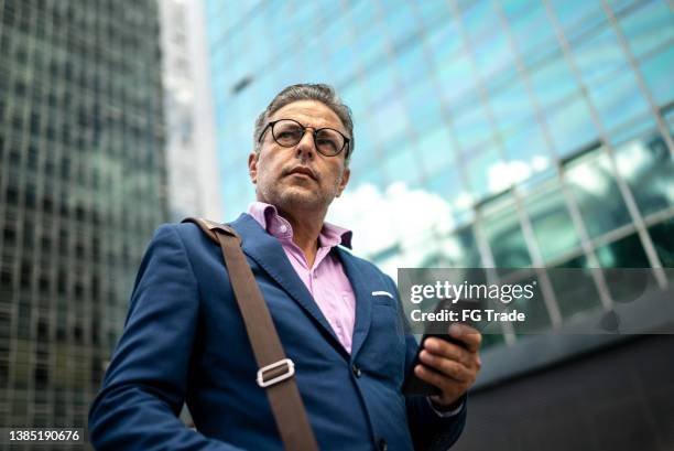 contemplative man looking away in the street - cfo stock pictures, royalty-free photos & images