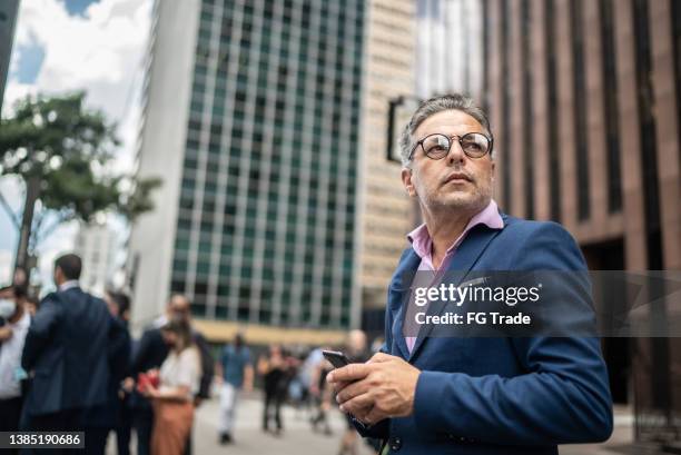 contemplative man looking away in the street - cfo imagens e fotografias de stock