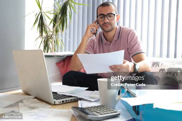 man doing home accounts - factura fotografías e imágenes de stock