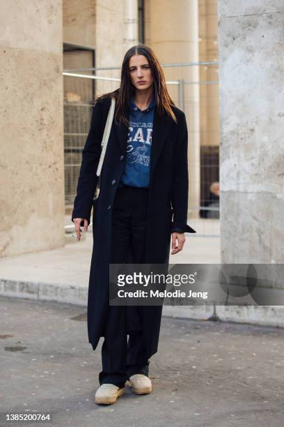 German model Rachel Marx wears a black coat, black pants, blue American football hoodie, and white puffy sneakers after the Rains show at Palais de...