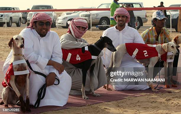 Emirati men wait with their Arabian saluki dogs for the start of the annual traditional race in Shweihan on the outskirts of Abu Dhabi on February...