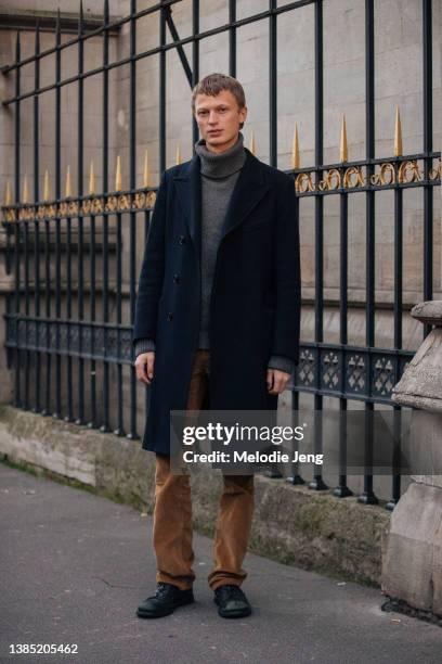 Model Jonas Gloeer wears a black peacoat, gray turtleneck cashmere sweater, brown pants, and black boots after the Jil Sander show during Paris...