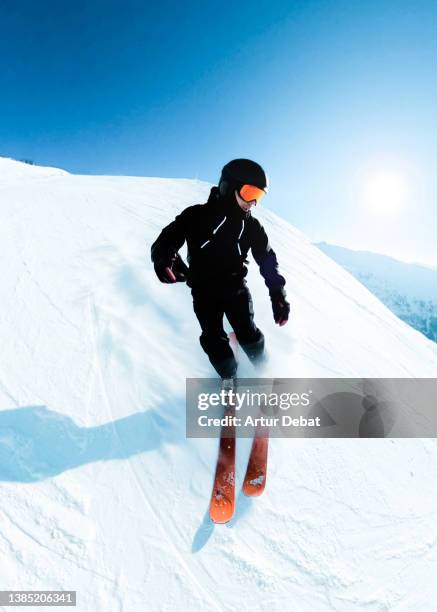 skier descending with snow powder splashing in the french alps. - skikleidung stock-fotos und bilder