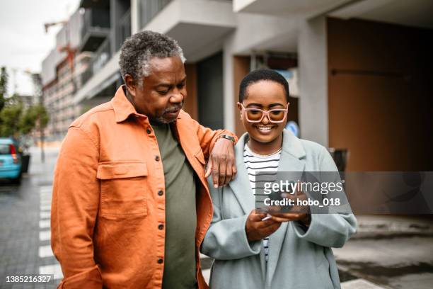 father and daughter tourists in city walk - man walking phone stock pictures, royalty-free photos & images