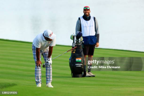 Anirban Lahiri of India reacts to his chip shot on the 18th hole as his caddie Tim Giuliano looks on during the final round of THE PLAYERS...