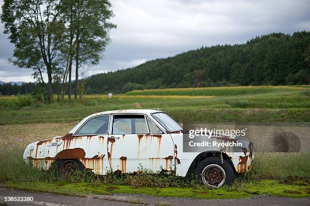 scrapped in the countryside - rusty old car fotografías e imágenes de stock