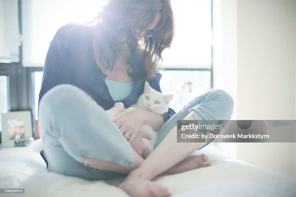 Young woman holding white cat