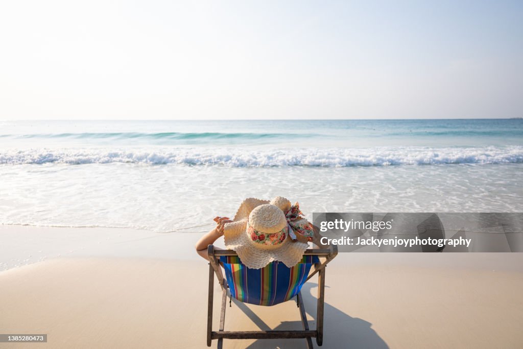 Woman relaxing in lawn chair on beach