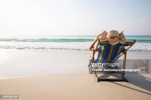 summer beach vacation concept, asia woman with hat relaxing and arm up on chair beach. - beach hut stock-fotos und bilder