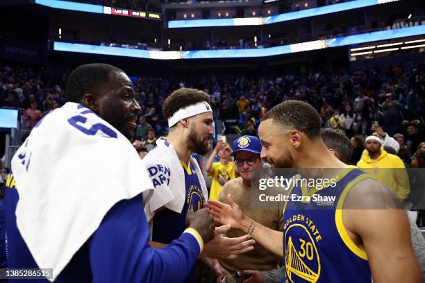 Stephen Curry, Klay Thompson and Draymond Green of the Golden State Warriors congratulate one another after they beat the Washington Wizards at Chase...