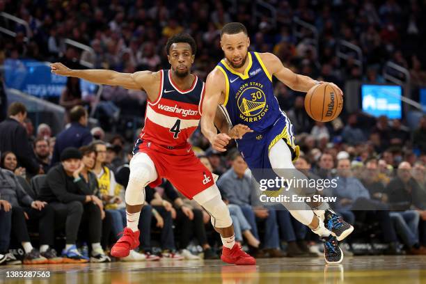 Stephen Curry of the Golden State Warriors dribbles past Ish Smith of the Washington Wizards at Chase Center on March 14, 2022 in San Francisco,...