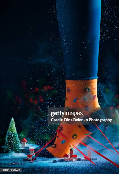 christmas sock on a feet standing in a tiny town, gulliver concept, festive still life - cartoon road above stock pictures, royalty-free photos & images