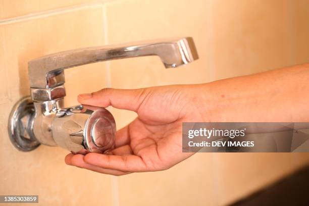 woman hand shut the faucet - water saving - faucet imagens e fotografias de stock