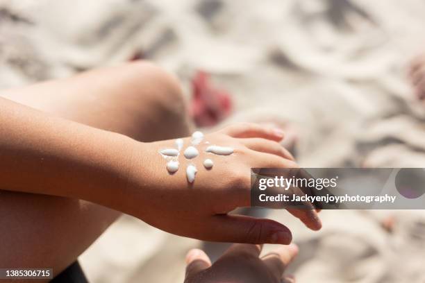 boy with sun shaped sunscreen on his hand - thailand beach stock-fotos und bilder