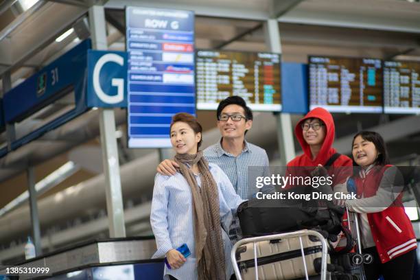 famille chinoise asiatique voyageant en avion en vacances et marchant dans le hall de l’aéroport avec des bagages - older couple travelling photos et images de collection