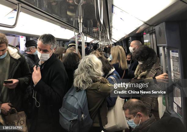 Passengers wearing protective face masks travel on a subway train on March 14, 2022 in Paris, France.