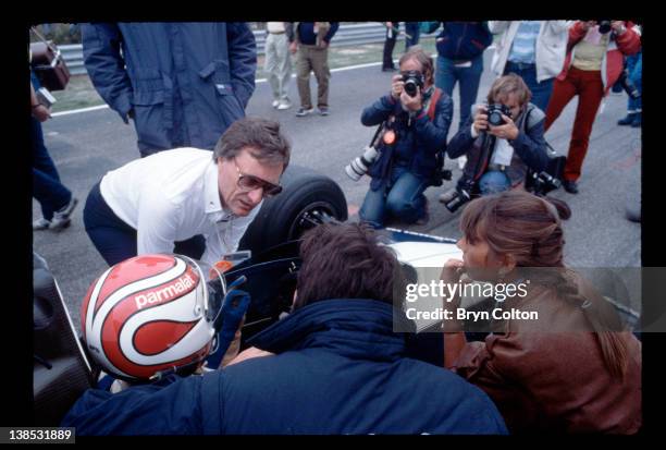 Bernie Ecclestone, owner of the Brabham Grand Prix team, left, talks with driver Nelson Piquet as he sits in his car on the starting grid for the...