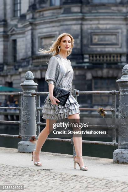 Influencer Maria Guenther wearing a silver metallic mini dress with layered skirt by Natascha Gruen, a black by by Saint Laurent, silver metallic...