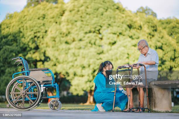 asian chinese female physical therapist guiding senior man stretching exercising his legs at public park - diabetic foot stock pictures, royalty-free photos & images