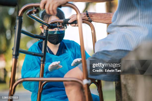 asian chinese female physical therapist guiding senior man stretching exercising his legs at public park - diabetic foot care stock pictures, royalty-free photos & images