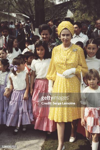 Queen Elizabeth II with a group of local children during her state visit to Mexico, 1975.