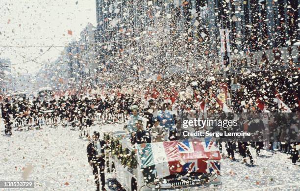 Queen Elizabeth II is showered with confetti during her state visit to Mexico, 1975. Her vehicle carries the flags of Mexico and the UK.